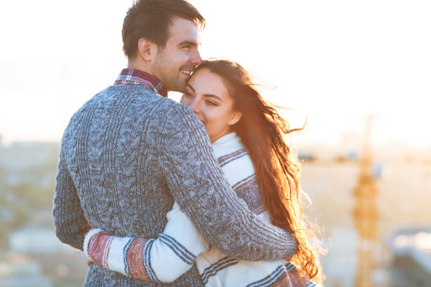 Young man and woman embrace and having fun outdoors Young man and woman embrace and having fun outdoors on the roof& Love and relations concept falling in love stock pictures, royalty-free photos & images