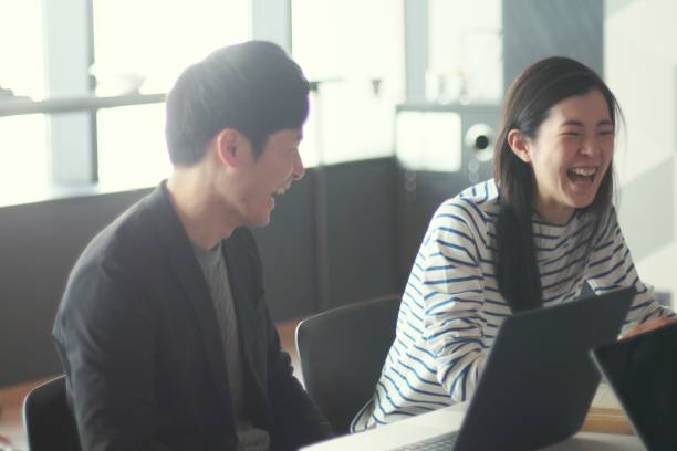 若い男性と女性の近代的なシェア オフィスで働く - 会議　笑顔 ストックフォトと画像