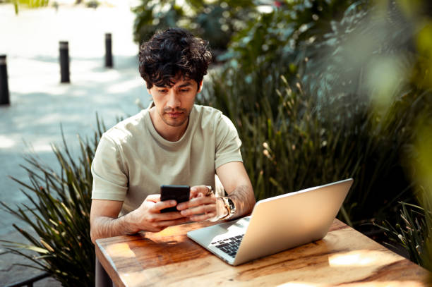 Young man at coffee shop using mobile phone stock photo