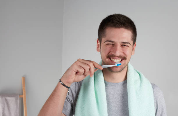 Young man brushing his teeth stock photo