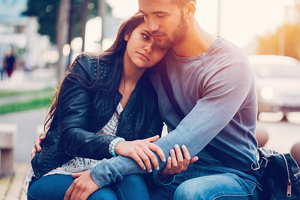 young man consoling his girlfriend - embrace man woman serious stockfoto's en -beelden
