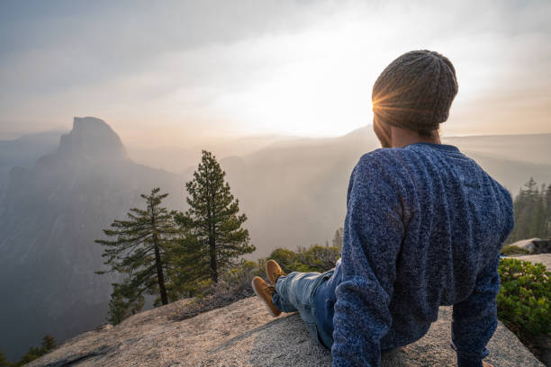 Young man contemplating view from top of Yosemite valley, USA stock photo