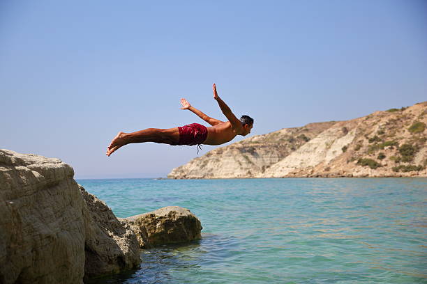 Young man diving Young man diving. cliff jumping stock pictures, royalty-free photos & images