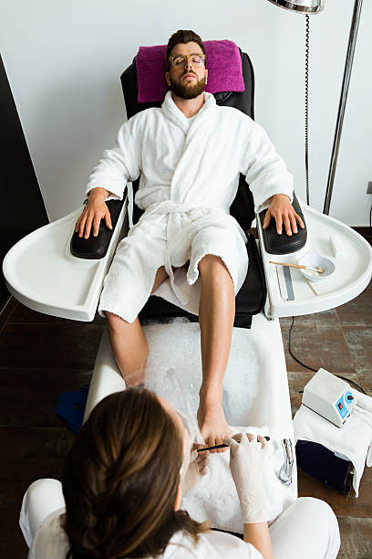 Young man doing pedicure in salon. Beauty concept. Portrait of young man doing pedicure in salon. Beauty concept. man pedicure stock pictures, royalty-free photos & images