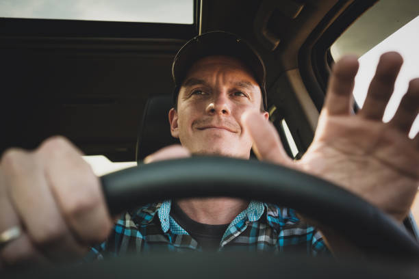 young man driving a car or truck. steering wheel. stock photo