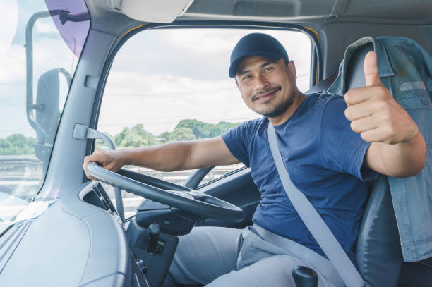 young man driving a car Smile Confidence Young Man Professional Truck Driver In Business Long transport truck driver stock pictures, royalty-free photos & images