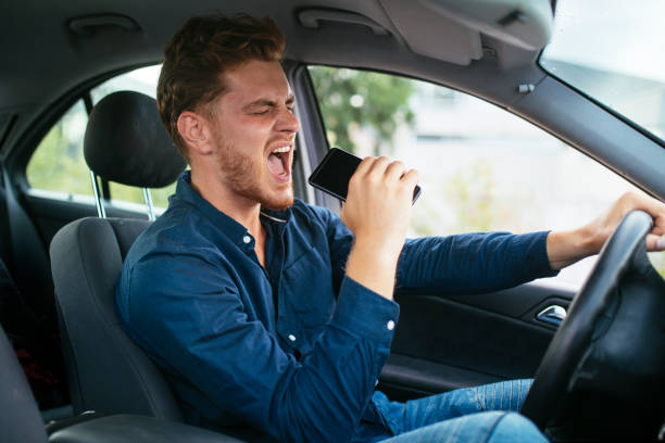 Young man driving and singing stock photo