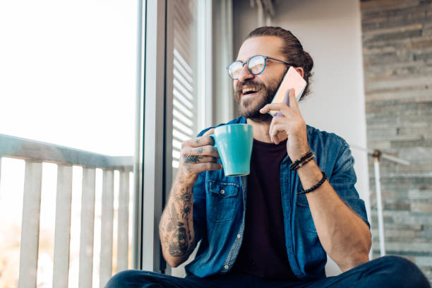 Young man enjoying coffee and talking on the phone stock photo