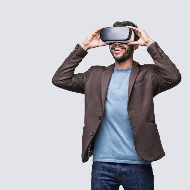 junger mann erlebt virtual-reality-brille headset - vr brille stock-fotos und bilder
