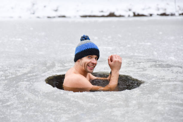 jongeman heeft bad in koud water en doet wim hof methode - ice swimming stockfoto's en -beelden