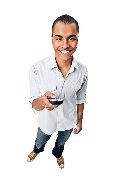 young man holding remote control - isolated - man,standing, elevated view,remote control stockfoto's en -beelden