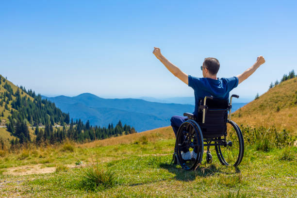 Young man in a wheelchair enjoying fresh air stock photo