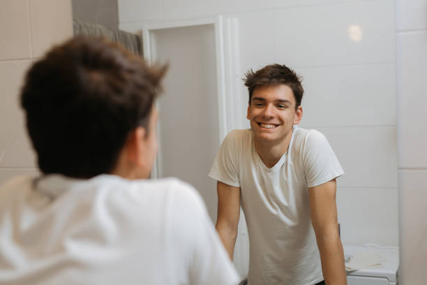 jeune homme dans la salle de bain - homme miroir photos et images de collection