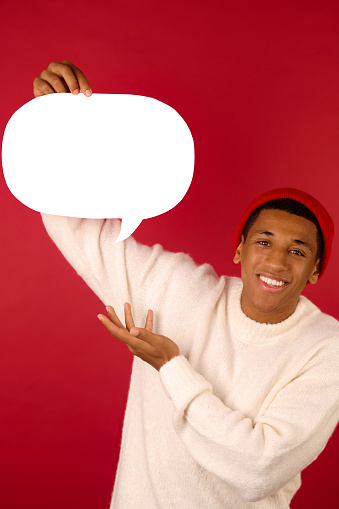 Communication. A young man in santa hat holding emoji