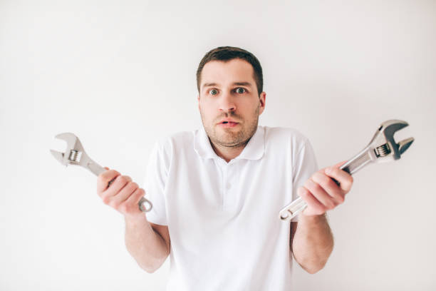 Young man isolated over white background. Confused guy hold two wrenches in hands and posing on camera. Repair man or plumber. Young man isolated over white background. Confused guy hold two wrenches in hands and posing on camera. Repair man or plumber vlad model photos stock pictures, royalty-free photos & images