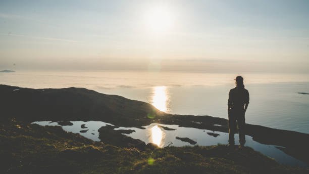 Young man look towards horizon in the mountain. Freedom. stock photo