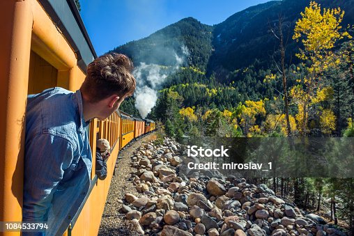 istock Young man looking out of train window 1084533794