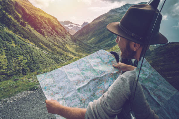 山道、スイス連邦共和国に近く道路地図を見て若い男 - ロードマップ ストックフォトと画像