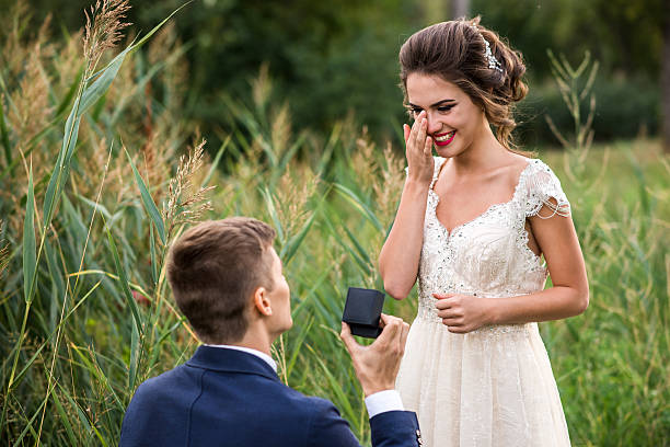 Young man makes a proposal to get married Young man makes a proposal to get married, the bride is crying from happiness fiancé stock pictures, royalty-free photos & images