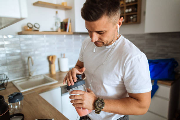 Young man making protein shake before training  protein stock pictures, royalty-free photos & images