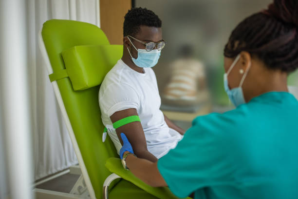 Young man on blood donation at medical clinic stock photo
