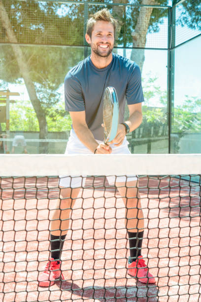 young man plays tennis on an open air court stock photo