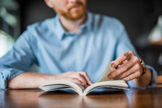 young man reading a book hand close up. - reading imagens e fotografias de stock