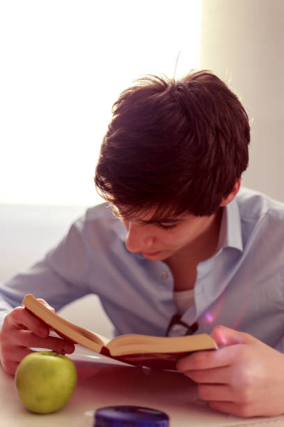 Young man reads a book stock photo