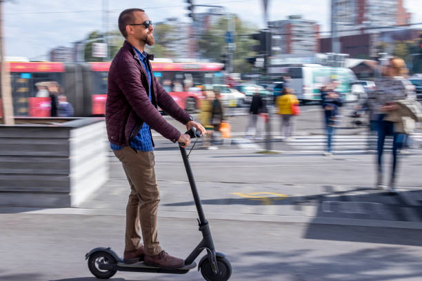 Young man riding electric scooter during rush hour stock photo