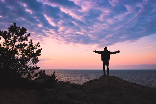 Young man rise hand and Refresh at the mountain Young man was able to get refreshed at cliff of mountain. motivated stock pictures, royalty-free photos & images