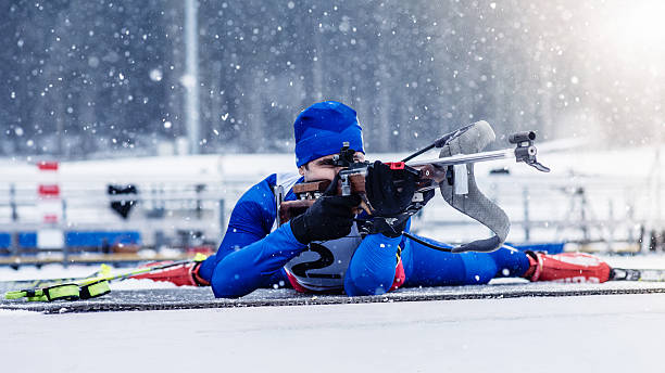 Young man shooting at biathlon training stock photo
