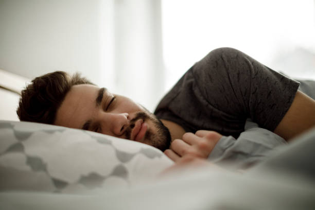 Young man sleeping in bed at home Young man sleeping in bed at home sleeping well stock pictures, royalty-free photos & images