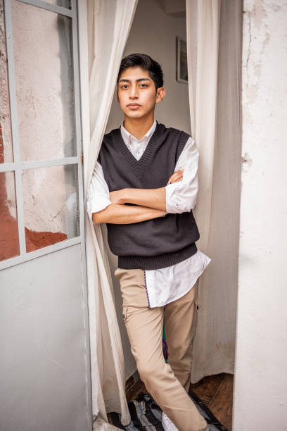 Young man standing at the front door stock photo