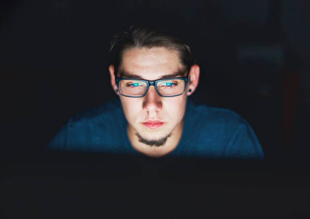 jonge man kijkt aandachtig computermonitor nachts - student night study stressed stockfoto's en -beelden