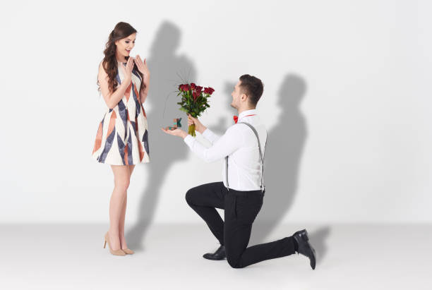 junger mann überrascht frau mit verlobung - papier blumen studio stock-fotos und bilder