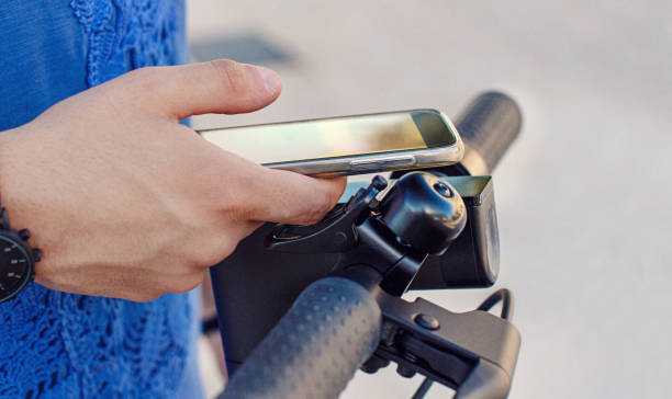 giovane che usa lo smartphone per sbloccare uno scooter elettrico condiviso - electric scooter foto e immagini stock