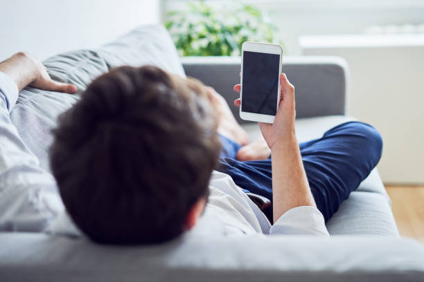2,428 Person Holding A Smartphone And Lying On The Sofa Stock Photos,  Pictures & Royalty-Free Images - iStock