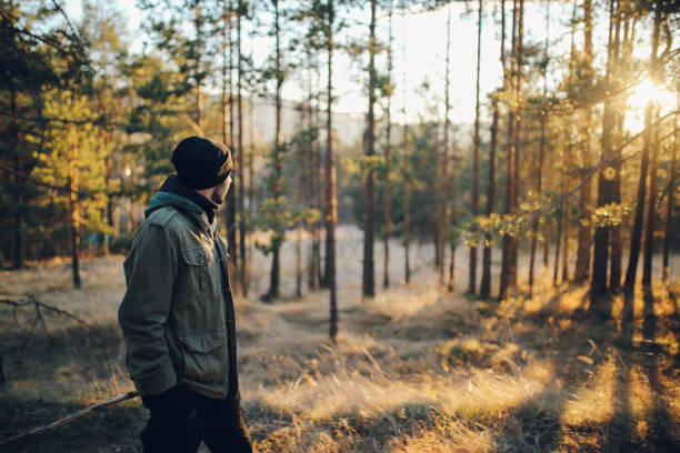 jeune homme marche dans la belle forêt en plein air - un seul homme photos et images de collection