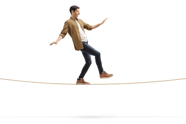 ロープの上を歩く若い男 - バランス ストックフォトと画像
