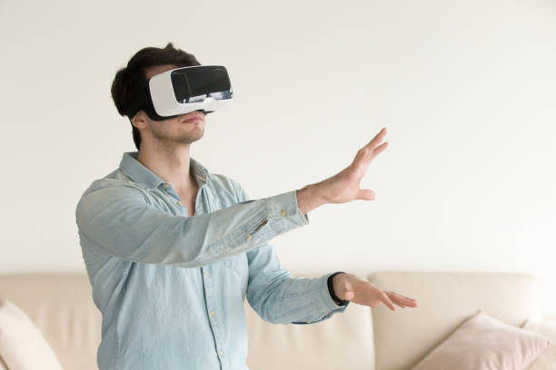ung man bär virtual reality-glasögon, vr-headset för smartphone - virtual reality headset bildbanksfoton och bilder