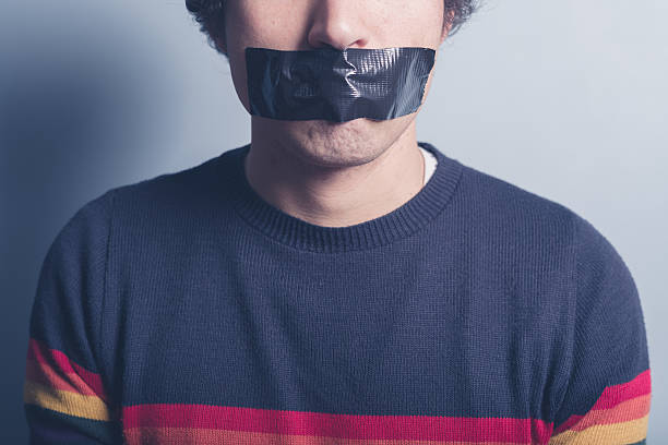 young man with tape covering his mouth - plakband mond stockfoto's en -beelden