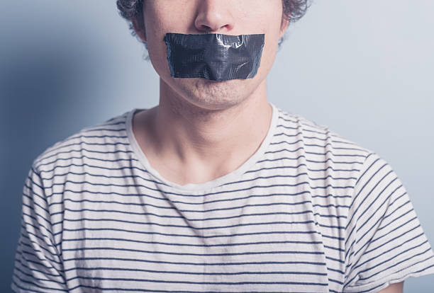 young man with tape covering his mouth - plakband mond stockfoto's en -beelden