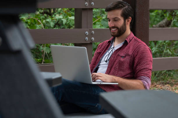 A young man working remotely on his laptop stock photo