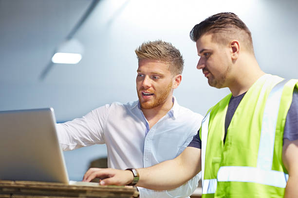 Young manager working with foreman in factory stock photo