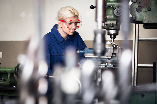 young mechanic / apprentice working on milling machine stock photo