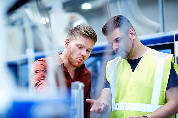 Young men working in manufacturing facility stock photo