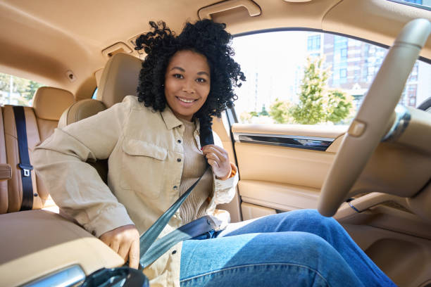 Young mixed race woman fastening her seat belt stock photo