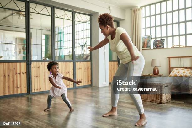 Young Mother and Daughter Doing Dance Exercises At Home