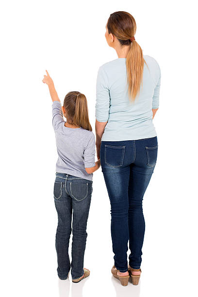 young mother and daughter pointing rear view of young mother and daughter pointing at empty space behind stock pictures, royalty-free photos & images