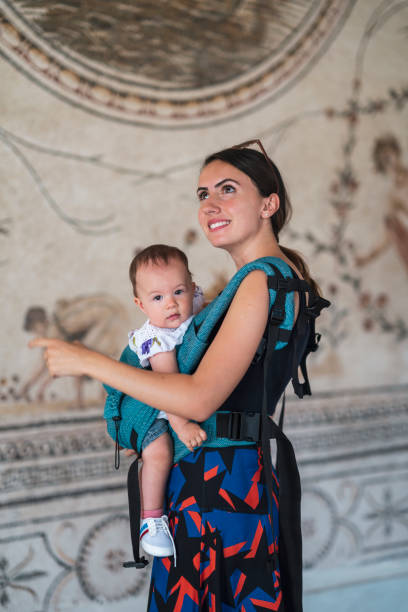 Young mother carrying her baby girl with baby carrier (kangaroo) Young mother carrying her baby girl with baby carrier (kangaroo) tunisian girls stock pictures, royalty-free photos & images